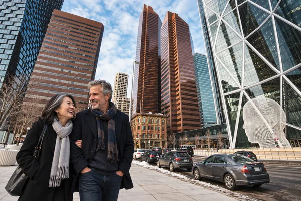 Couple walking in downtown Calgary beside the Wonderland sculpture