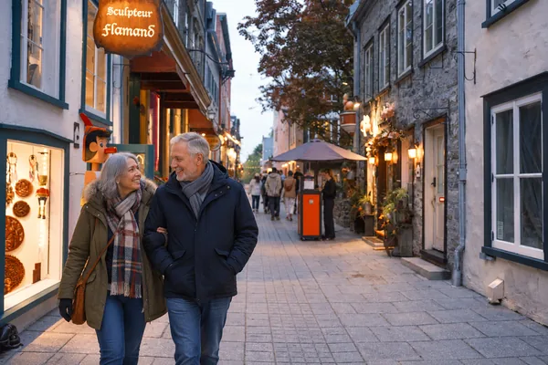 Couple strolling a lantern lit street in Old Quebec at dusk