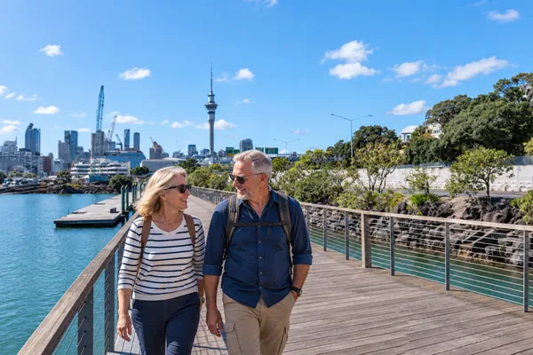 Couple walking on the Auckland waterfront boardwalk