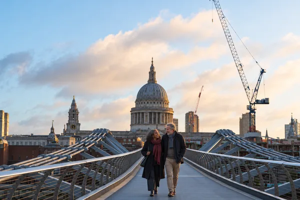 Couple walking across a London bridge towards St Paul's Cathedral