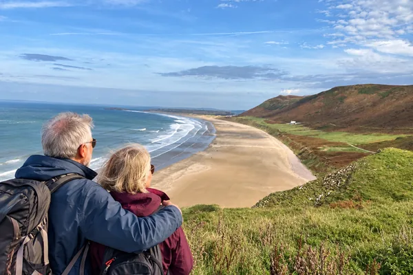 Couple looking out over Rhossili Bay on the Gower, Wales